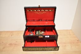 A vintage three tiered tooled leather jewellery box containing jewellery and accessories, to include