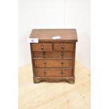 A miniature oak two over three chest of drawers, 20cm by 16cm by 9cm.