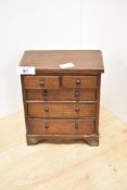 A miniature oak two over three chest of drawers, 20cm by 16cm by 9cm.