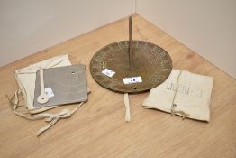 An antique brass sundial, having Welsh dragons to centre, approx 17cm, sold with a Heliograph