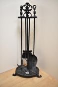 A Victorian cast iron fireplace companion set, finished in black, and measuring 73cm tall