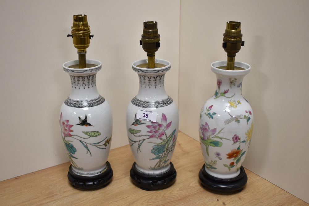 Three 20th Century Chinese porcelain Famille Rose lamp bases, converted from vases, raised on