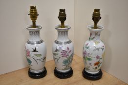 Three 20th Century Chinese porcelain Famille Rose lamp bases, converted from vases, raised on