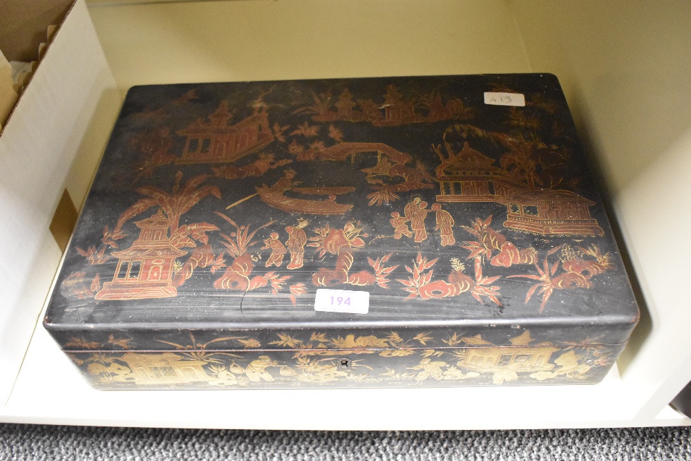 An oriental lacquered box, having black ground with red and gilt Chinoiserie scene, with handles