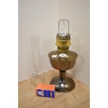 A vintage brass oil lamp base with glass chimney.