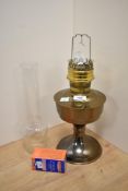 A vintage brass oil lamp base with glass chimney.