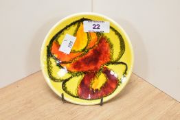 A mid-20th Century Poole pottery circular Delphis dish, on yellow ground, number 49, and measuring