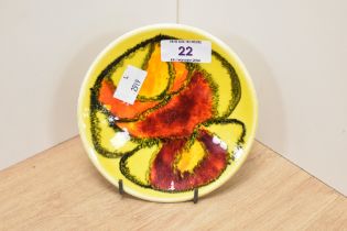 A mid-20th Century Poole pottery circular Delphis dish, on yellow ground, number 49, and measuring