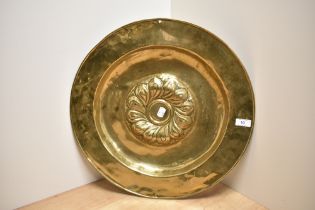 An antique Continental brass alms dish, the raised centre with a swirl of gadroons, measuring 46cm