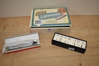 A boxed Hinkler harmonica, with book for learning, a Suzuki Winner harmonica, and a box of wooden