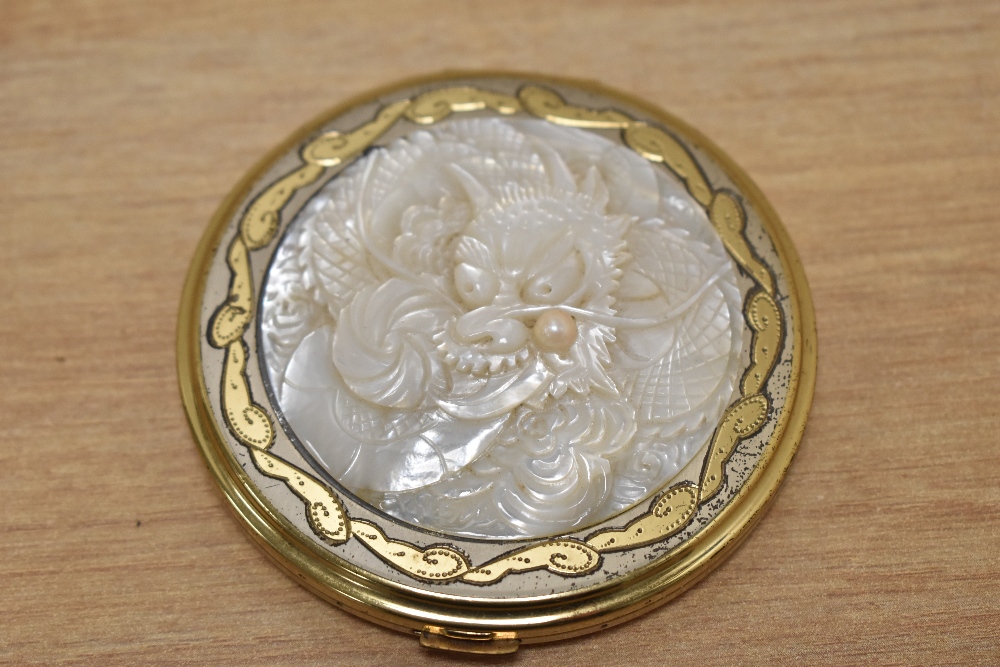 A vintage brass compact, having Mother of Pearl style insert to centre depicting Japanese dragon. - Image 2 of 3