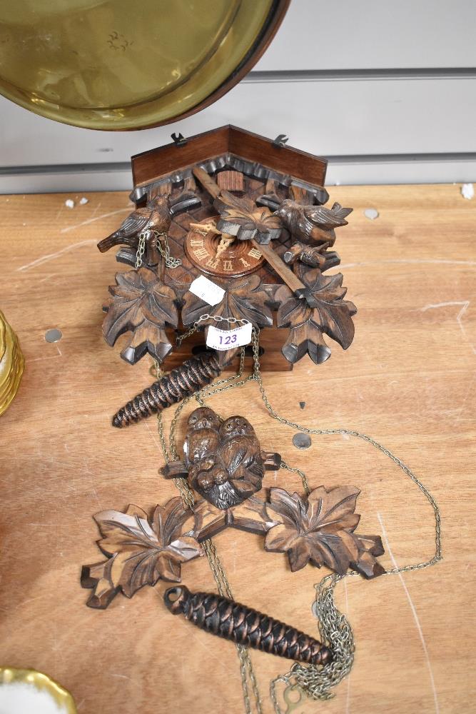 A vintage German Black Forest style cuckoo clock with acorn weights