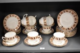 An assortment of breakfast cups and saucers and side plates, having white ground with dappled border