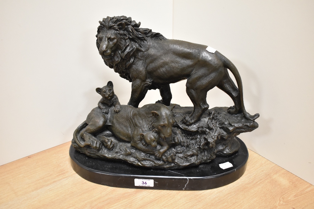 An attractive cast patinated metal lion figure group, raised upon an oval variegated marble base,