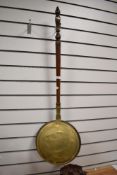 A traditional copper and brass warming pan having mahogany handle