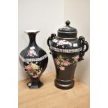 An early 20th century black urn with lid, having floral decoration on black ground, AF and a similar