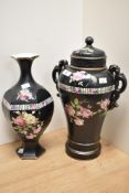 An early 20th century black urn with lid, having floral decoration on black ground, AF and a similar