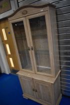 A modern laminate limed oak effect display cabinet with double cupboard under, dimensions approx.