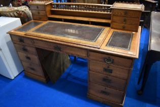 A Victorian oak desk having spindle back with two sets of three stationery drawers to top, raised