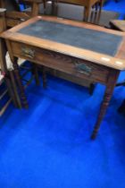 A Victorian oak side table/desk having skiver top, frieze drawer and turned legs, dimensions approx.