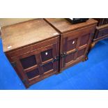 A pair of Arts and Crafts oak bedside cabinets with medieval style panelled doors and metalwork