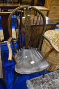 A traditional stained frame windsor chair having spindle and wheelback