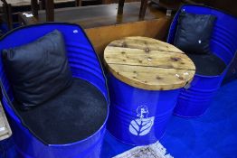 A patio set , constructed from oil drums, with New Holland branding, comprising two seats and