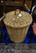 A large wicker laundry basket, height approx 76cm