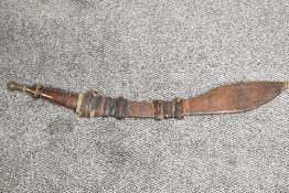 A Nigerian Takouba type Sword.leather grip with brass pommel, leather scabbard with leaf shaped