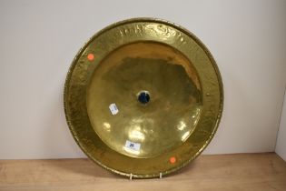 A late 19th Century hand beaten brass alms style dish, of Arts and Crafts design, with central
