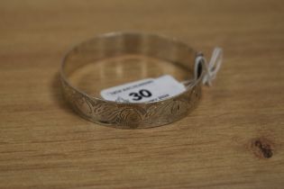 A white metal buckle form bangle with engraved decoration