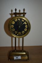 An early 20th Century British made gravity clock, the brass frame holding the weighted circular