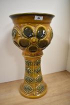 A mid-20th Century glazed pottery jardiniere stand, having a moulded floral design against a tan