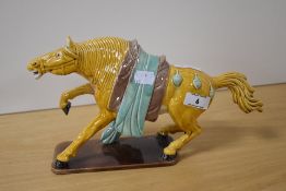 A Chinese glazed ceramic Tang style horse ornament, on a rectangular base, and measuring 31cm long
