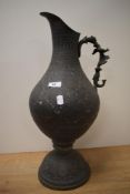 An Islamic copper ewer, with profuse incised foliate design, having a figural moulded handle, and