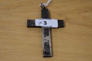 An oversized white metal crucifix pendant of brutalist, hollow form, approx. 9cm long