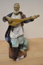 A 20th Century Chinese pottery Mudman musician, with impressed mark to the underside, measuring 22cm