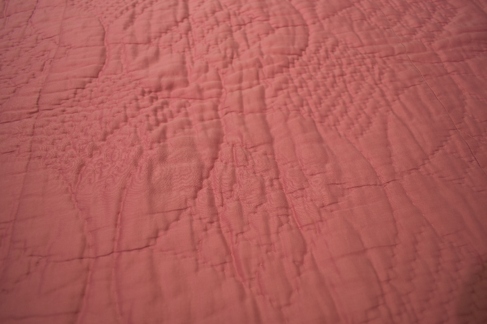 An early 20th century hand stitched Durham quilt, having block rose pink to one side and floral - Image 3 of 5