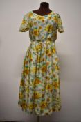 A gossamer fine silk 1950s day dress, having abstract rose print of bright gold tones, pink and