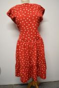 A 1950's red dress, having white polka dot pattern, tiered skirt and rear metal zip, larger size.
