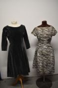 A 1950s grey dress, having pink, silver and black foliate pattern, bows to the hips and side brass