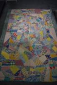 A vintage bed throw, using colourful patches of random form, predominantly 1940s and 50s fabrics