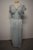 A pale blue 1940s nightdress, having tie fastening to waist and machine lace and embroidery to