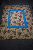 A mid century reversible single bed throw, having floral pattern to one side and block patchwork