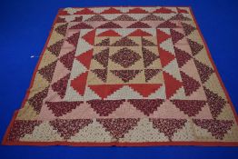 A 19th century patchwork coverlet, using floral, red, black and beige fabrics, having natural cotton