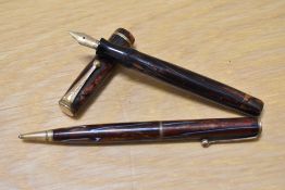 A Parker Moderne Duette Jr button fill fountain pen and propelling pencil set in bronze with blue