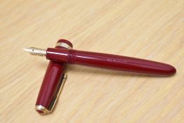 A Parker Duofold Junior aerometric fill fountain pen in red with decorative band to the cap having