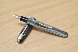 A Waterman 512V lever fill fountain pen in green striated with two narrow bands to the cap having