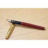 A Parker 75 converter fill fountain pen in burgundy laque with gold cap which has ruby coloured