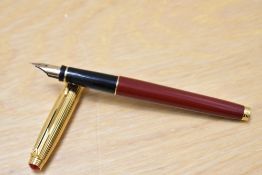 A Parker 75 converter fill fountain pen in burgundy laque with gold cap which has ruby coloured